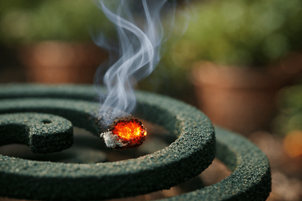 Mosquito repellent coil burning with glowing ember and rising smoke in macro detail