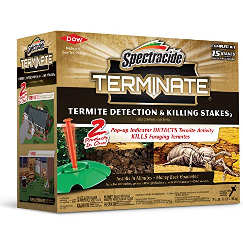 Over-the-counter termite detection and killing stakes installed in soil beside a home foundation