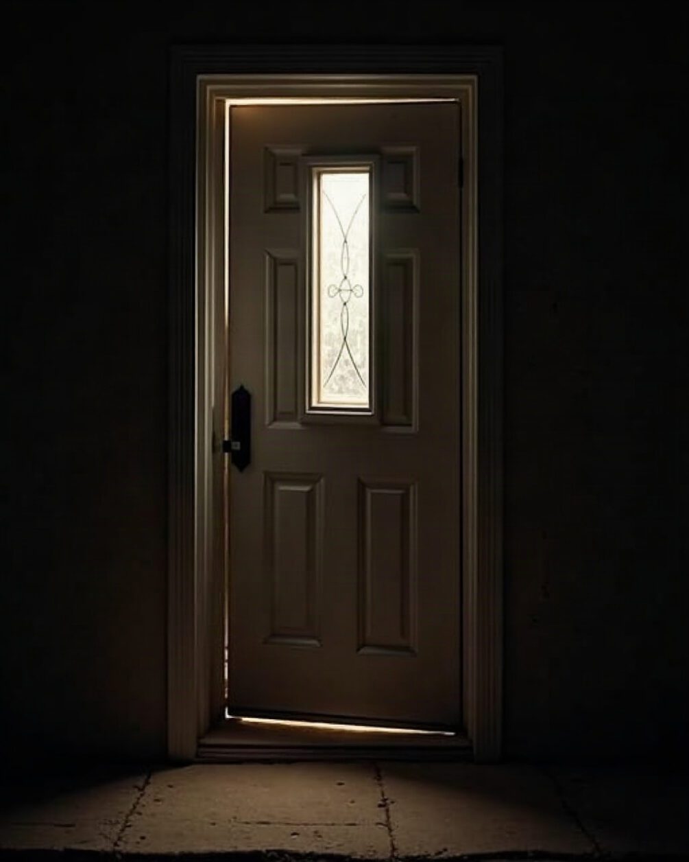 An exterior door threshold seen from inside at night with a narrow gap of darkness beneath the door and porch